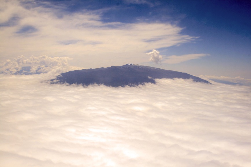 A view of Hawaii's highest peak, Mauna Kea, poking up above the clouds - taken from our airplane.